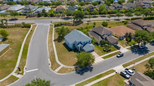 an aerial view of a swimming pool with outdoor seating and yard