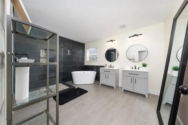 a spacious bathroom with a double vanity sink a mirror and shower