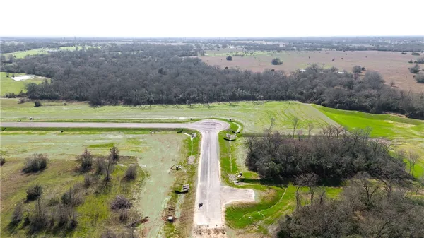 an aerial view of a golf course with a lake view