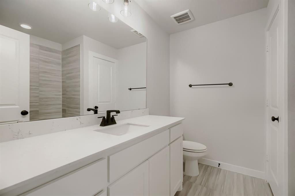 4414 Windy Point Road Oak Point, TX 75068 - Photo 24 of 27 a bathroom with a sink a toilet and shower