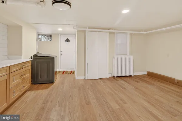 a view of a kitchen with wooden floor and stainless steel appliances