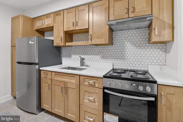 a kitchen with stainless steel appliances granite countertop a stove and a refrigerator