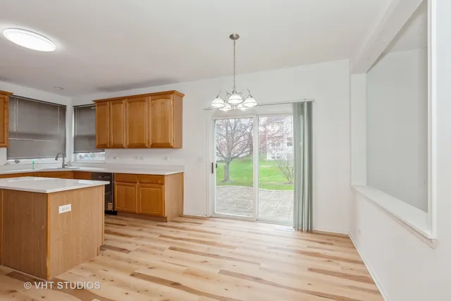 a kitchen with stainless steel appliances granite countertop a stove a sink dishwasher and a fireplace with wooden floor