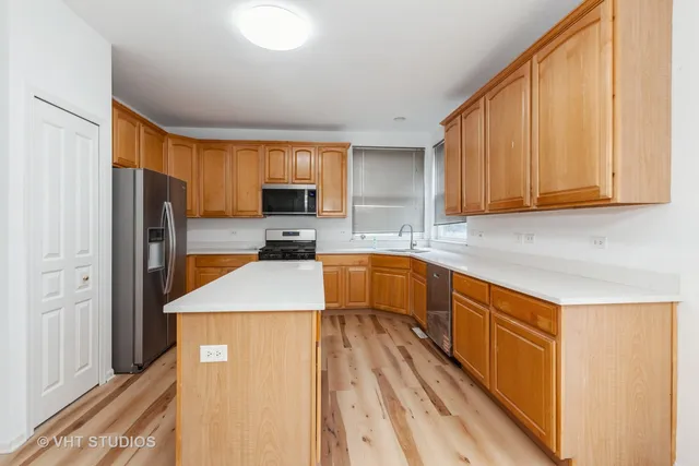 a kitchen with wooden cabinets and stainless steel appliances