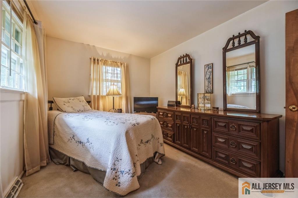 129 Cottrell Road Old Bridge, NJ 07747 - Photo 13 of 25 a spacious bedroom with a bed a dresser and windows