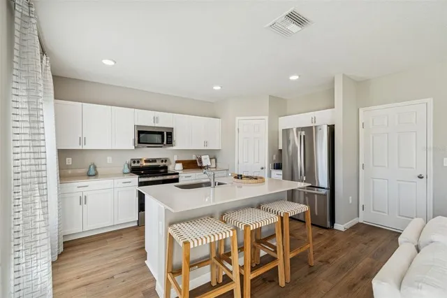a kitchen with a dining table chairs and a refrigerator