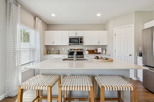 a kitchen with stainless steel appliances granite countertop a sink stove and microwave