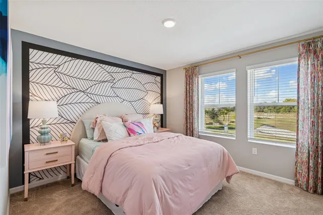 a bedroom with a bed and a lamp on dresser