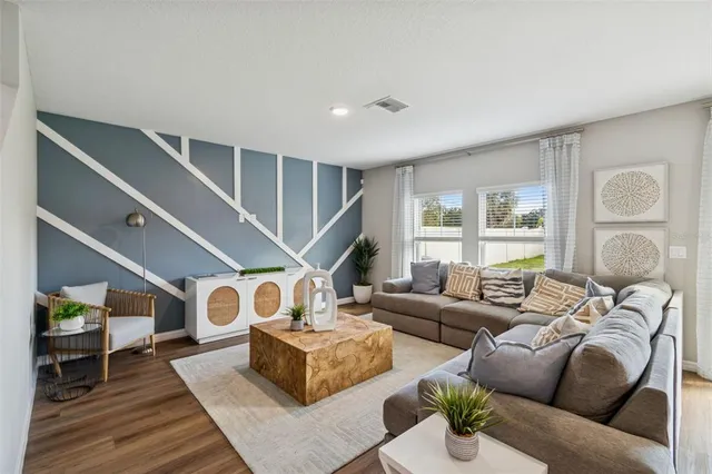a living room with furniture and a ceiling fan