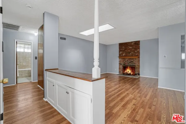a hallway with wooden floor a fireplace and entryway