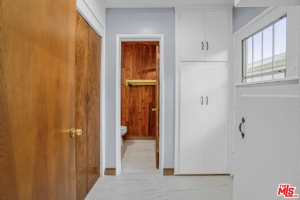 a view of a hallway with closet and a window