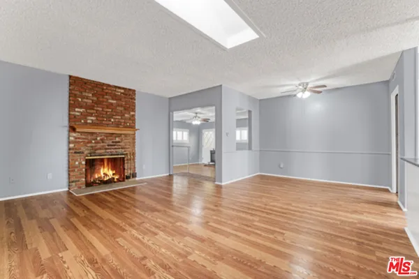 a view of an empty room with a fireplace and a window