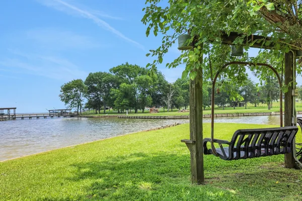 a view of a lake from a yard with large trees