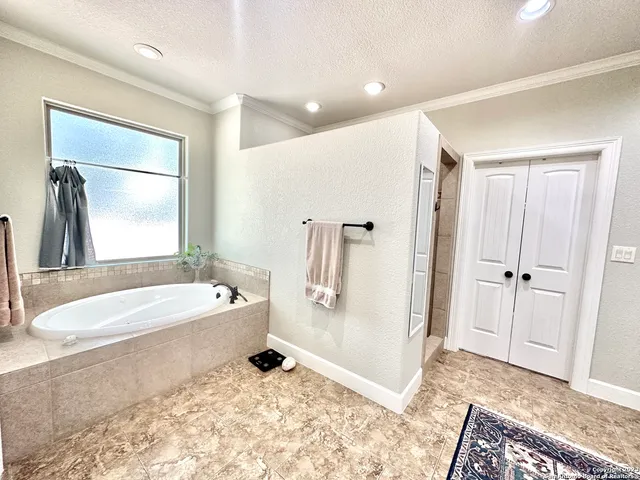 a spacious bathroom with a tub sink and mirror