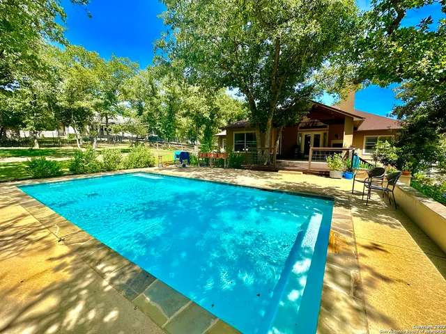a view of a house with swimming pool and sitting area