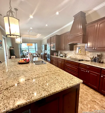 a kitchen with stainless steel appliances kitchen island granite countertop a sink stove and cabinets