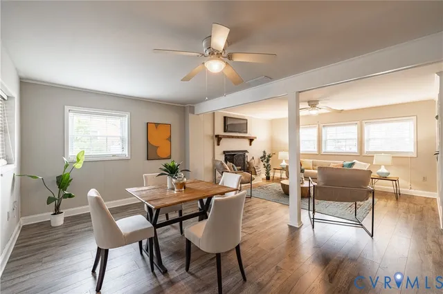 a dining room with wooden floor a chandelier a glass table and chairs