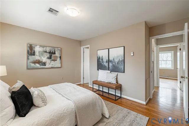 a bedroom with a bed and a painting on the wall