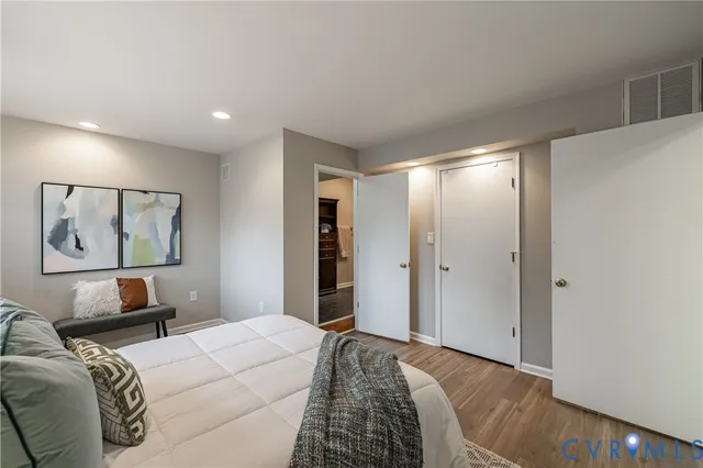 a bedroom with a large bed and a chandelier