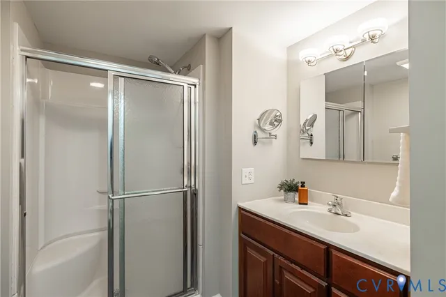a bathroom with a shower sink vanity and mirror