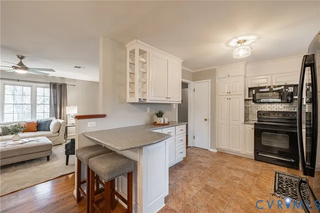 a kitchen with a stove a refrigerator and a sink with wooden floor