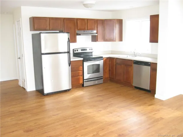 a kitchen with a refrigerator sink and cabinets