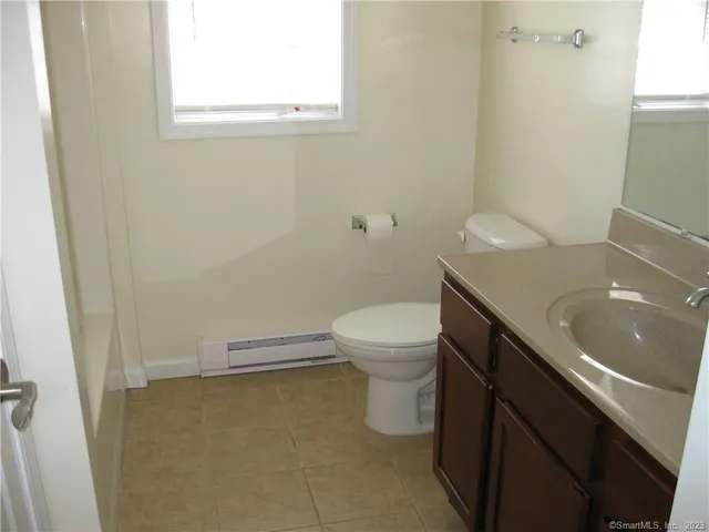 a bathroom with a sink a toilet and a window