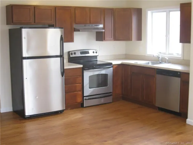 a kitchen with a refrigerator sink and cabinets