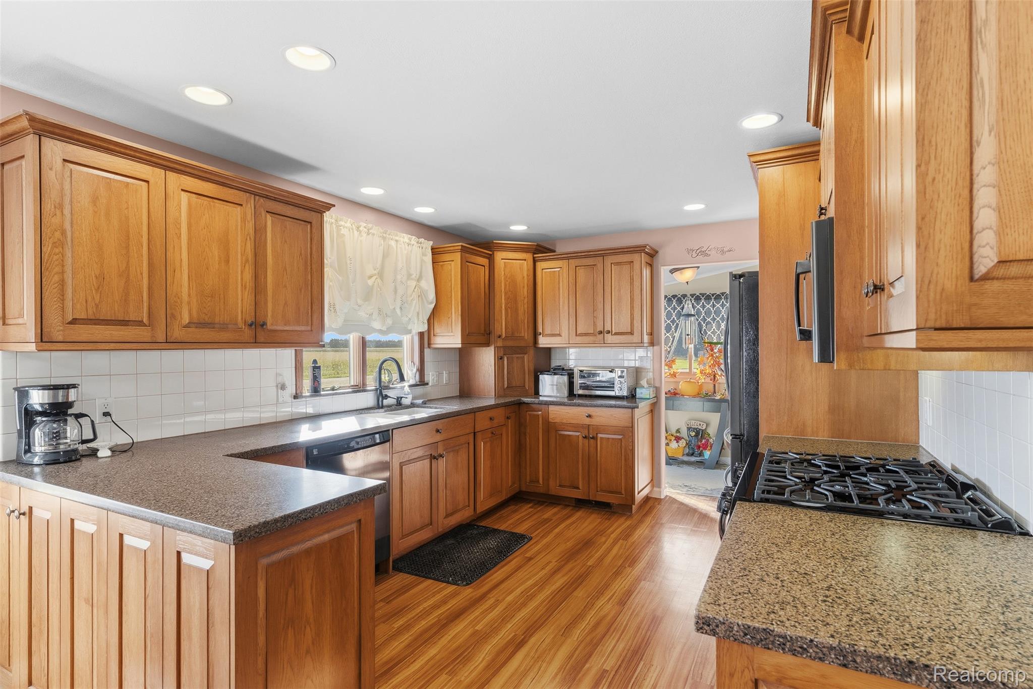 2227 North Graf Road Caro, MI 48723 - Photo 20 of 51 Wood-finish flooring, recessed lighting, U-shaped countertops, stainless steel dishwasher, and a gas range
