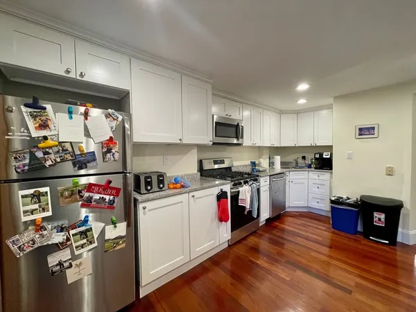 a kitchen with stainless steel appliances granite countertop a refrigerator sink and stove