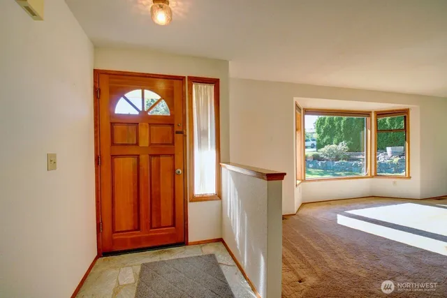an empty room with windows closet and front door