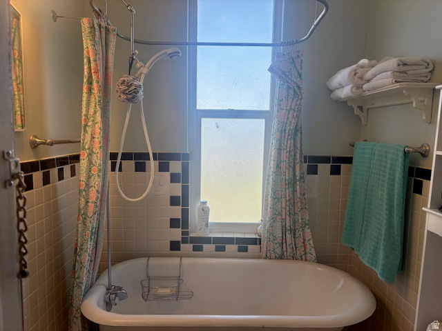 5264 West 5500th Street South Hooper, UT 84315 - Photo 13 of 20 Full bathroom with shower / bath combo with shower curtain, a wainscoted wall, and tile walls