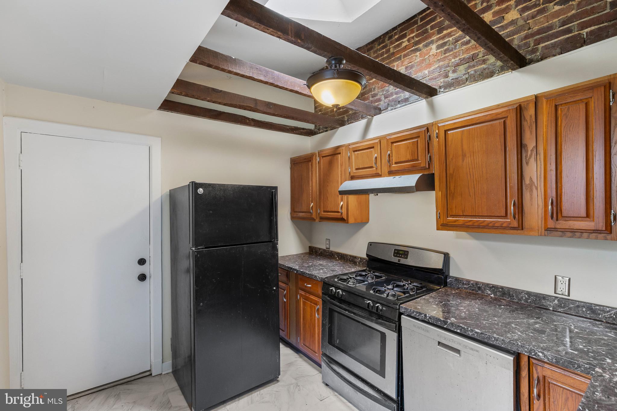 119 South Poppleton Street Baltimore, MD 21201 - Photo 12 of 27 a kitchen with stainless steel appliances granite countertop a refrigerator a stove and a sink