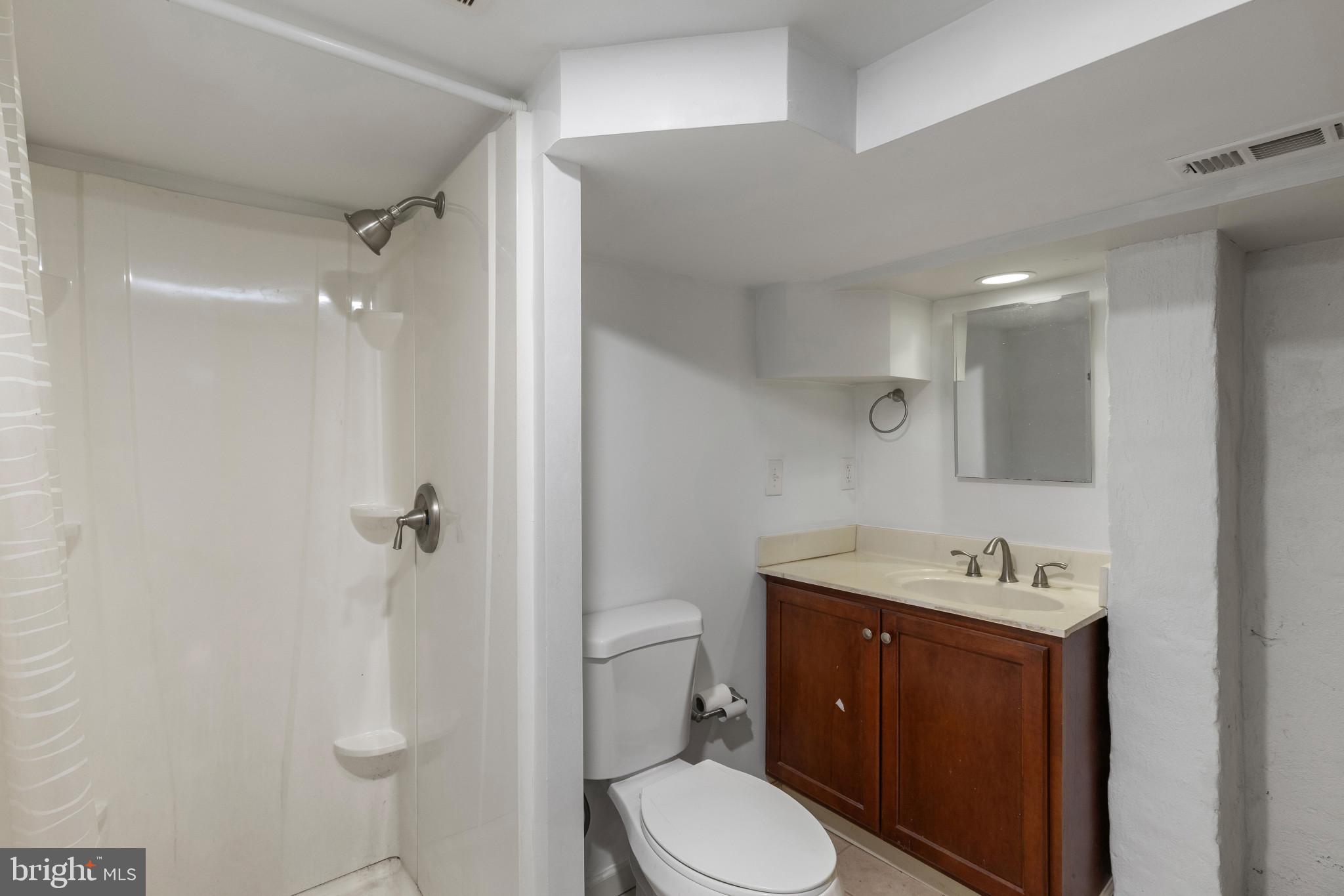 119 South Poppleton Street Baltimore, MD 21201 - Photo 14 of 27 a bathroom with a sink toilet vanity and shower