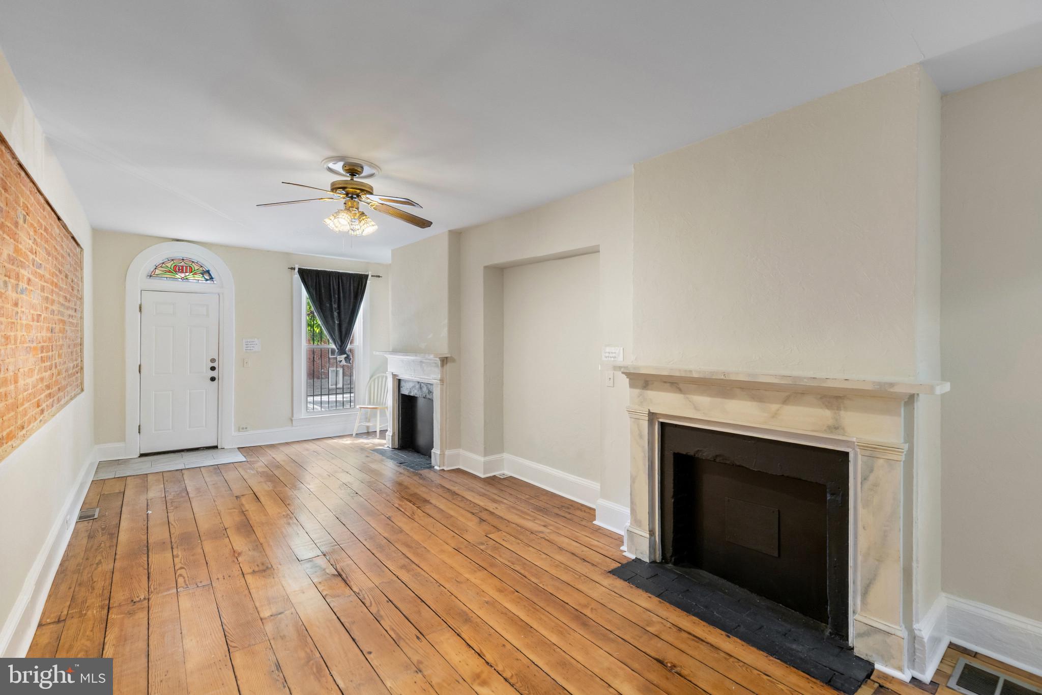 119 South Poppleton Street Baltimore, MD 21201 - Photo 6 of 27 a view of empty room with wooden floor and fireplace