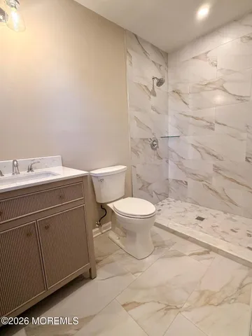 a bathroom with a toilet sink vanity and shower