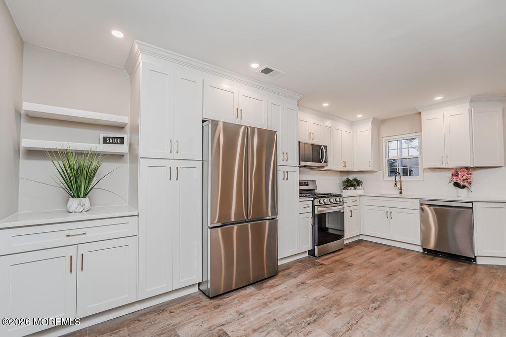 3 Gatley Close, Unit 1000 Freehold, NJ 07728 - Photo 5 of 24 a kitchen with white cabinets and stainless steel appliances