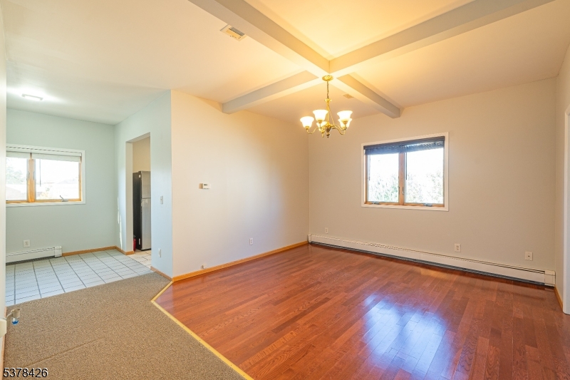 an empty room with a chandelier fan and windows