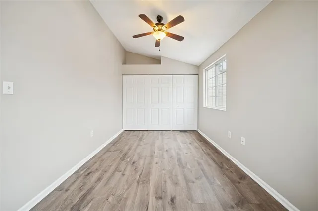 an empty room with a window and a ceiling fan