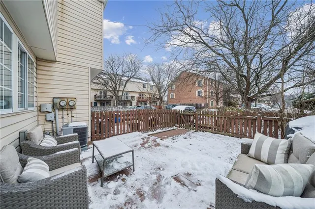 a view of a roof deck with couches and wooden fence