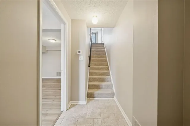 a view of a hallway with stairs and a white door