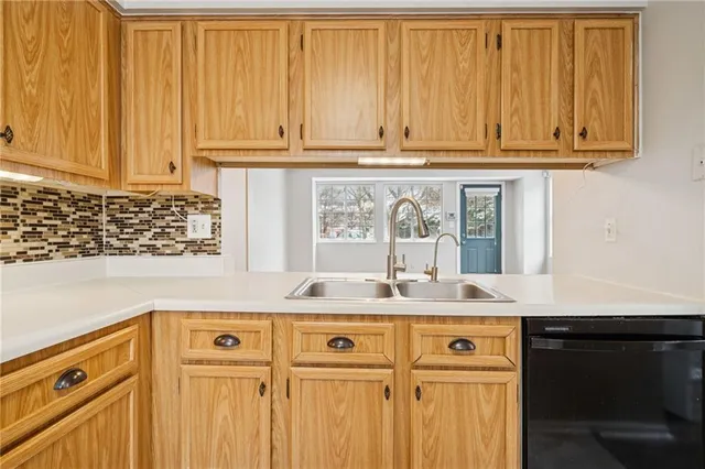 a sink with granite countertop white cabinets and a wooden floor