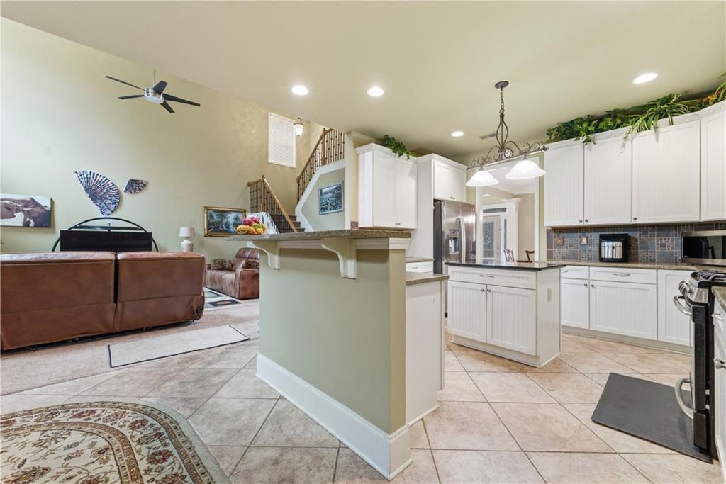 3411 Lynne Road Powder Springs, GA 30127 - Photo 12 of 27 a kitchen with kitchen island granite countertop a sink a counter top space appliances and cabinets
