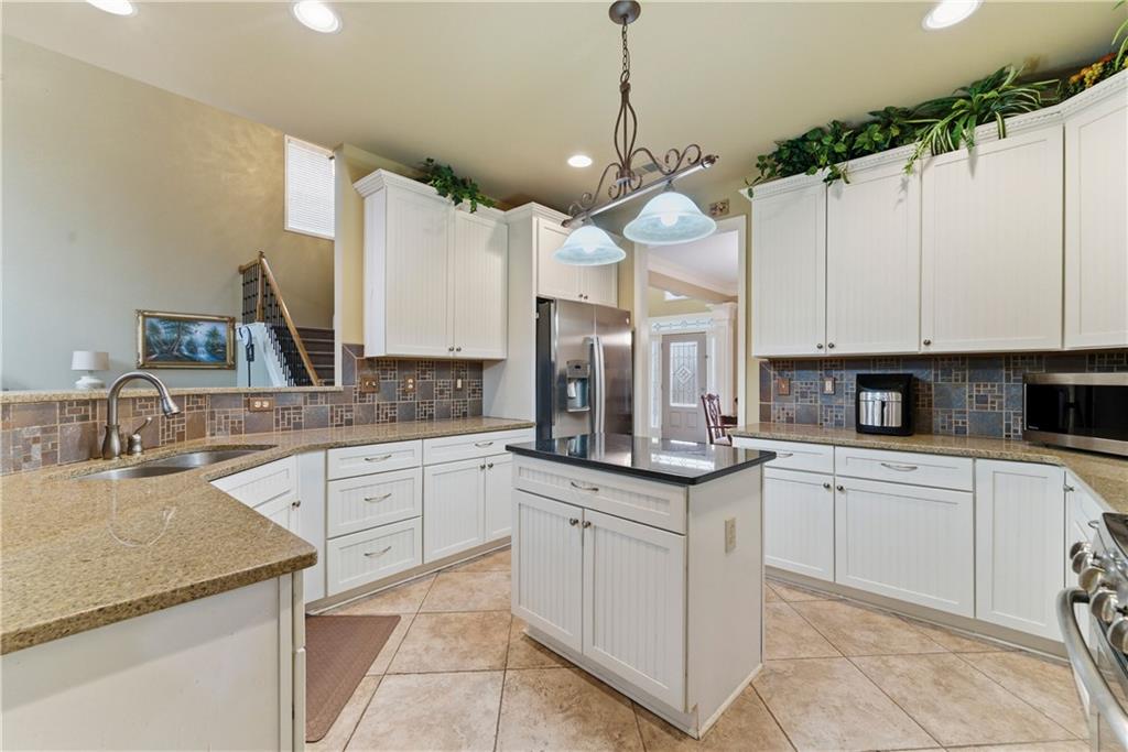 3411 Lynne Road Powder Springs, GA 30127 - Photo 13 of 27 a kitchen with kitchen island granite countertop a sink a counter space appliances and cabinets