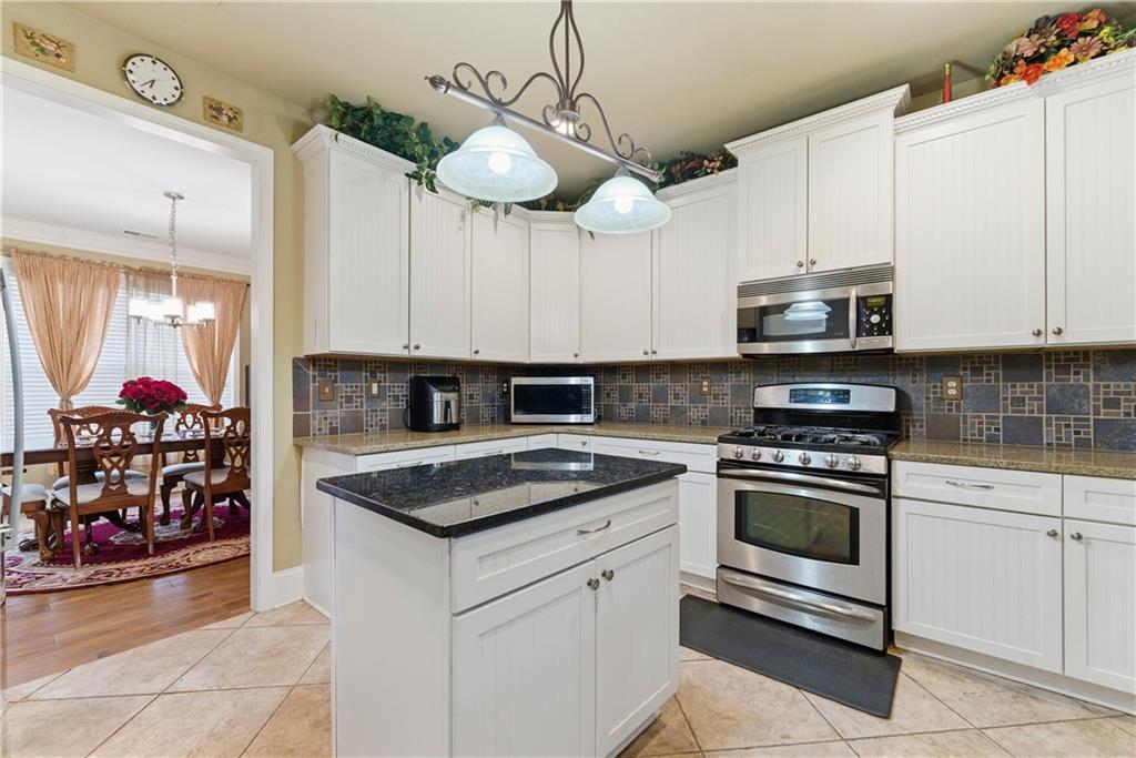 3411 Lynne Road Powder Springs, GA 30127 - Photo 14 of 27 a kitchen with stainless steel appliances granite countertop a stove and cabinets