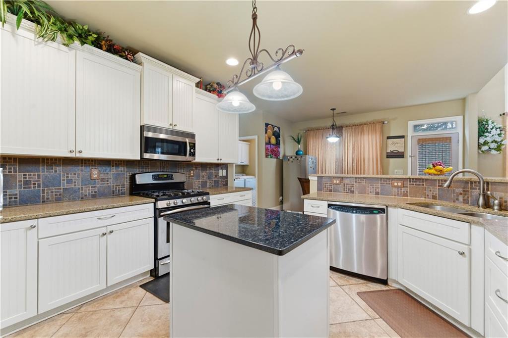 3411 Lynne Road Powder Springs, GA 30127 - Photo 15 of 27 a kitchen with stainless steel appliances granite countertop a sink a stove and cabinets