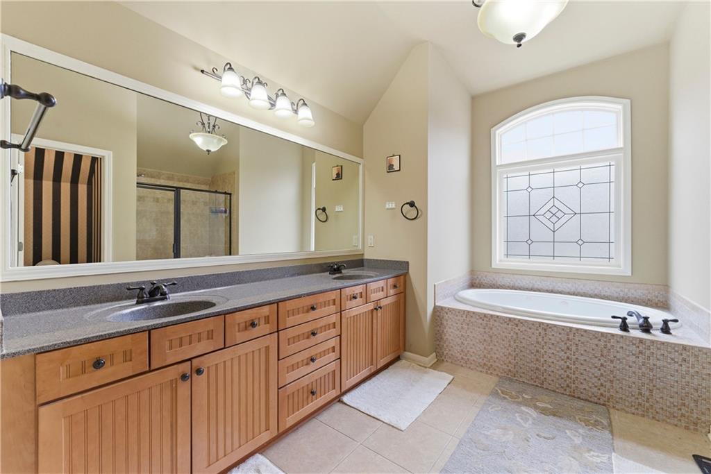 3411 Lynne Road Powder Springs, GA 30127 - Photo 24 of 27 a spacious bathroom with a granite countertop double vanity sink a mirror and a bathtub