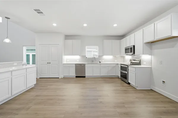 a kitchen with white cabinets and white appliances