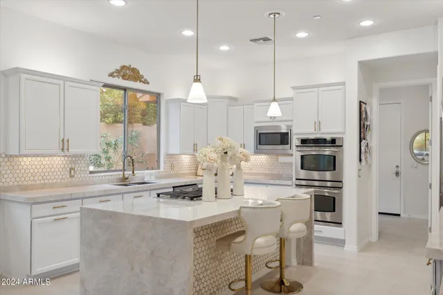 a large living room with furniture a fireplace and a potted plant