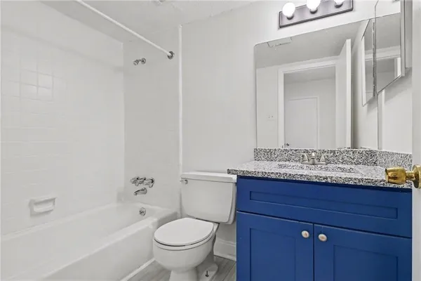 a bathroom with a granite countertop sink vanity and mirror